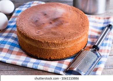 Homemade Sponge Cake And Grater On A Wooden Table