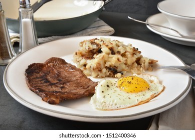 Homemade Steak And Egg Breakfast With Hashbrowns Next To A Cast Iron Skillet