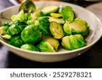 Homemade steamed Brussels sprouts served in a bowl. A vibrant close-up of steamed Brussels sprouts served in a simple white bowl.