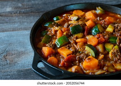 Homemade Stew With Ground Beef And Vegetable Served Isolated In A Cast Iron Pan On Wooden Table