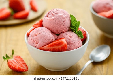 Homemade strawberry ice cream in a bowl on the wooden table. Healthy summer dessert. Selective Focus - Powered by Shutterstock