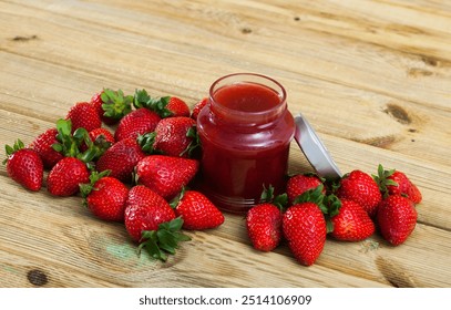 Homemade strawberry jam and fresh ripe strawberries on wooden background