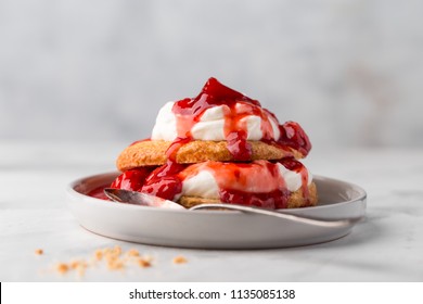 Homemade strawberry shortcakes with whipped cream on light concrete background 