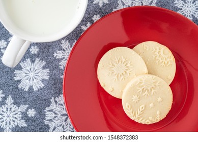 Homemade Sugar Cookies On A Red Plate, Snowflake Background, Mug Of Milk
