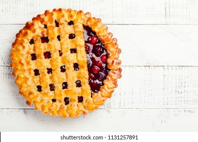 Homemade summer berry pie on rustic wooden background with copy space. Top view.