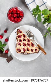 Homemade Tasty Triangular Russian Cake Monastic Hut With Cherries, White Cream, Chocolate On A White Plate. Selective Focus