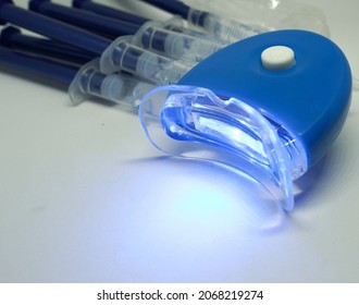 Homemade Teeth Whitening Kit With Blue Led Light On White Background