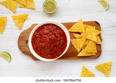 Homemade Tomato Salsa And Nachos On A Rustic Wooden Board On A White Wooden Table, Top View. Flat Lay, Overhead, From Above. 