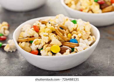 Homemade Trail Mix For Kids With Chocolate Candy, Popcorn, Pretzels And Nuts In White Bowls