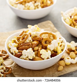 Homemade Trail Or Snack Mix With Popcorn, Pretzels And Nuts In White Bowls