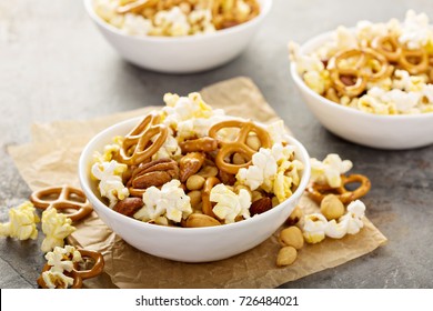 Homemade Trail Or Snack Mix With Popcorn, Pretzels And Nuts In White Bowls