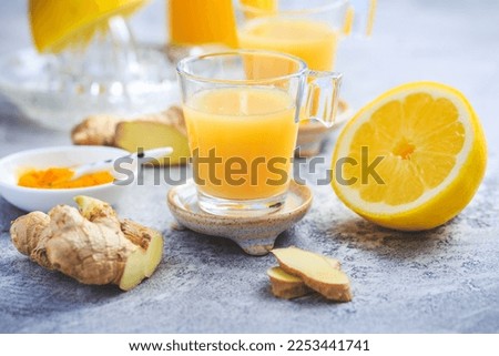 Homemade turmeric lemon ginger shots in small glasses, healthy Ginger Lemon Turmeric Shot ? ideal to boost the immune system during the winter