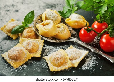 Homemade Uncooked Freshly Prepared Italian Ravioli Pasta With Fresh Basil And Tomatoes In A Rustic Kitchen In A Close Up View
