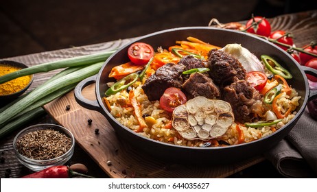 Homemade Uzbek Pilaf From Lamb Served In Cast Iron Cookware.