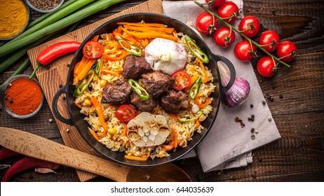 Homemade Uzbek Pilaf From Lamb Served In Cast Iron Cookware.