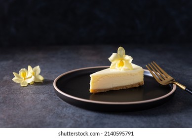 Homemade Vanilla Cheesecake With Vanilla Flower On Dark Background - Healthy Organic Summer Dessert Pie Cheesecake. Delicious Cheesecake New York. Side View, Copy Space. Menu, Recipe, Confectionery