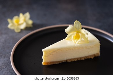 Homemade vanilla cheesecake with vanilla flower on dark background - healthy organic summer dessert pie cheesecake. Delicious Cheesecake New York. Side view, close up. Menu, recipe, confectionery