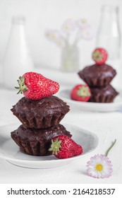 Homemade vegan chocolate muffins with starwberries on a white plate. Gluten free dessert. Healthy breakfast concept.