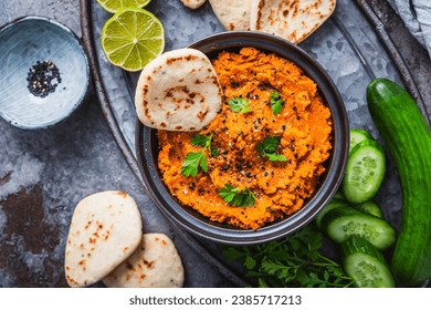 Homemade vegan Harissa carrot and lentil spread or dip with flatbread and cucumber