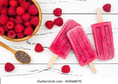 Homemade Vegan Raspberry Coconut Milk Popsicles - Ice Pops - Paletas With Chia Seeds On Rustic White Wooden Background