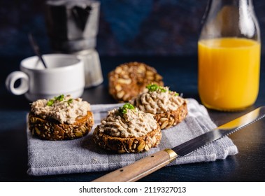 Homemade vegan tuna spread served on whole grain bread, with a coffee and orange juice on the side. On a dark table top. - Shutterstock ID 2119327013