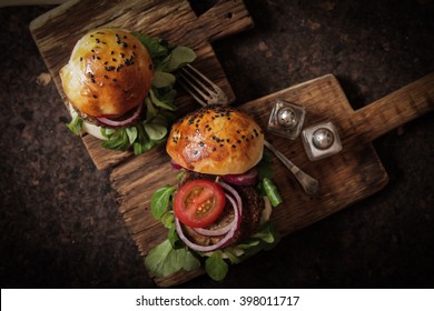 Homemade Veggie Burger In A Bun With Sesame Seeds Of Beer. Delicious Fast Food For Vegans. On A Wooden Background. Flat Lay. Top View.