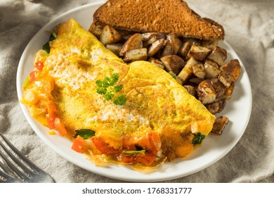 Homemade Veggie Omelette With Cheese Potatoes And Toast