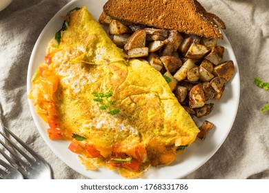 Homemade Veggie Omelette With Cheese Potatoes And Toast