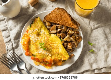 Homemade Veggie Omelette With Cheese Potatoes And Toast