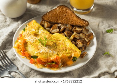 Homemade Veggie Omelette With Cheese Potatoes And Toast