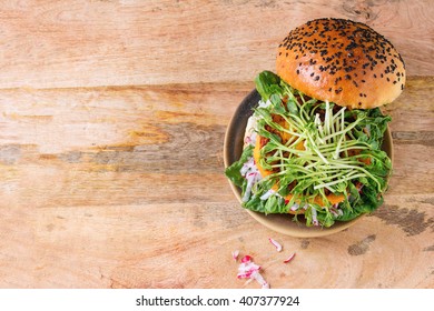 Homemade Veggie Sweet Potato Burger With Fresh Radish And Pea Sprouts Served On Clay Plate Over Wooden Textured Background. Top View. With Copy Space