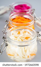 Homemade village fermented sauerkrauts, red cabbage and korean carrot in glass jars, gray background. Concept probiotics food, Supplement for gut health . Adaptogens. Superfood, Close up.