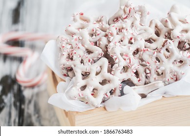 Homemade White Chocolate Or Yogurt Covered Pretzels With Pieces Of Crushed Candy Cane. Selective Focus With Blurred Foreground And Background. Heart Shaped Canes On The Table.