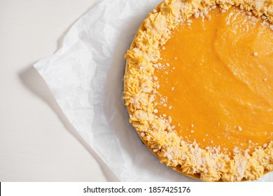 Homemade Yellow Cake With Nuts And Lemon On Parchment Paper. Food Delivery. Homemade Baking. Side View. Delicious Round Tart With Nuts On The Wooden Table.