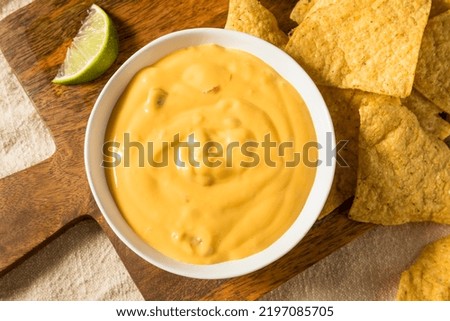 Homemade Yellow Queso Cheese Dip with Tortilla Chips and Lime Foto stock © 
