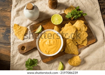 Homemade Yellow Queso Cheese Dip with Tortilla Chips and Lime Stockfoto © 