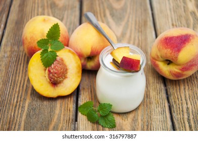 Homemade yogurt with fresh peaches on a wooden background