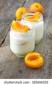 homemade yogurt with peach on a wooden background