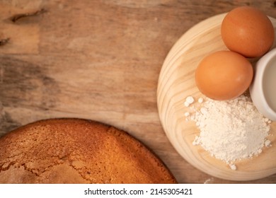 Homemade Yogurt Sponge Cake Served With Fresh Eggs, Flour And Oat Milk On A Wooden Board On A Wooden Base 