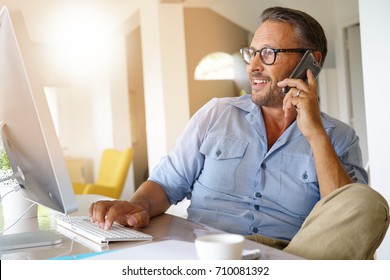 Home-office businessman talking on phone