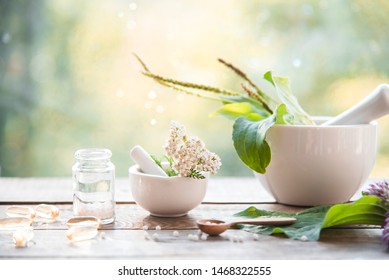 homeopathic granules, capsules and plants on a wooden table on a natural background. homeopathy, naturopathy and alternative medicine - Shutterstock ID 1468322555