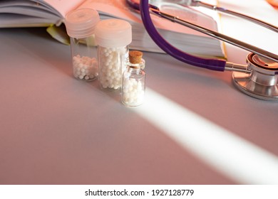 Homeopathic Granules In Storage Flasks. In The Background, A Book On Homeopathic Treatment.