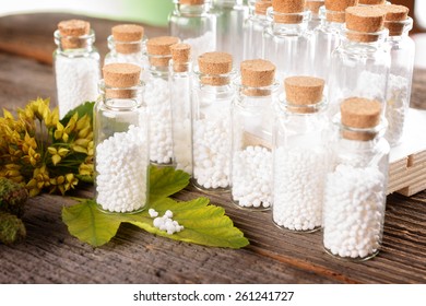 Homöopathische Lactose-Zuckerglobeln in Glasflaschen mit Pflanzen