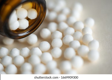Homeopathic pills in bottles on the white background. Homeopathy. Alternative medicine. Close-up.