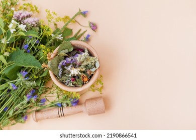 Homeopathy and herbal medicine concept. Bouquet of wildflowers and wooden mortar and pestle with dry herbs on a beige background with copy space - Shutterstock ID 2190866541