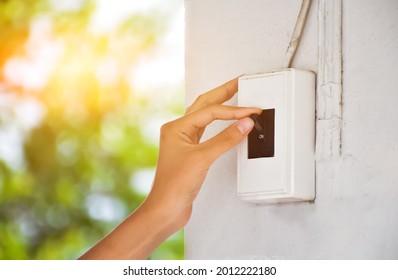 Homeowner Is Pulling Down The Circuit Breaker On The Wall From On To Off, Concept For Saving Energy At Home. Soft And Selective Focus.