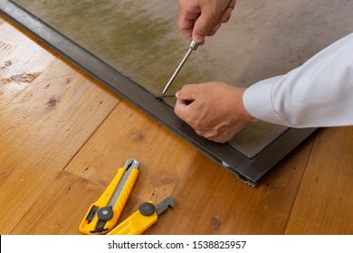 Homeowner Repairing His Window Screen