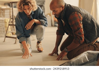 Homeowners collaborating on a home renovation. They discuss and plan the redesign of their kitchen's flooring tiles. Married couple working together, focusing on the DIY project.  - Powered by Shutterstock