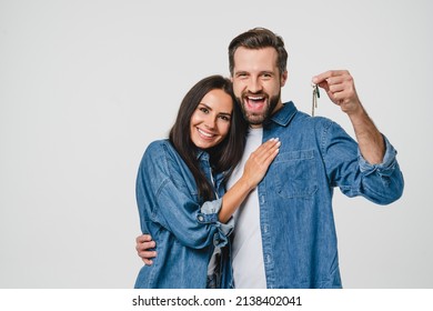 Homeowners. Happy young caucasian couple spouses wife and husband holding car house flat appartment keys, celebrating new purchase buying real estate isolated in white background. Mortgage loan - Shutterstock ID 2138402041