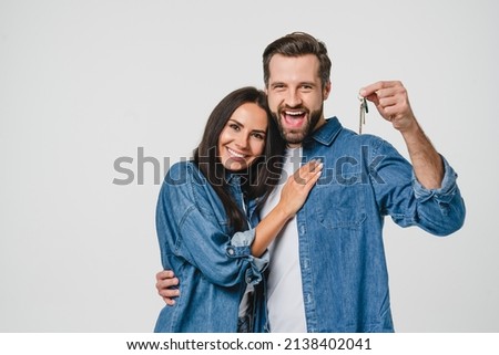 Homeowners. Happy young caucasian couple spouses wife and husband holding car house flat appartment keys, celebrating new purchase buying real estate isolated in white background. Mortgage loan